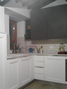 - une cuisine avec des placards blancs et un évier dans l'établissement Casa Renacci, à Subbiano