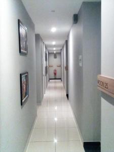 a hallway with a long corridor with white tile floors at Rivero Boutique Hotel Melaka in Malacca