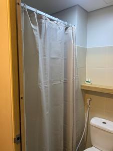 a shower curtain in a bathroom with a toilet at The grass residences sm north edsa cozy comfortable heart of Quezon City in Manila