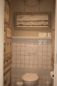 uma casa de banho com WC e uma fotografia na parede em Les 4 Tilleuls em Crozant