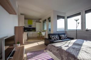 a bedroom with a bed and a living room at Air-Conditioned City View Apartment 24h check-in in Bratislava