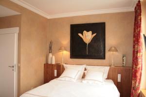 una camera da letto con un letto e un dipinto a fiori sul muro di Les 4 Tilleuls a Crozant