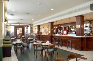 a restaurant with tables and chairs and a bar at Hotel Lasa Sport in Valladolid
