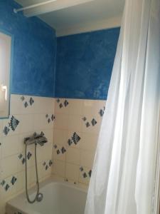 ein Bad mit einer Badewanne und einem Duschvorhang in der Unterkunft Maison Valras accès direct à la plage in Valras-Plage
