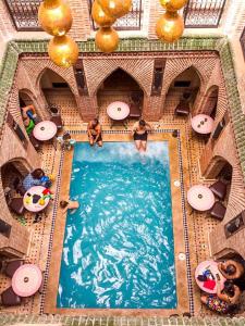 an overhead view of a swimming pool with people in it at Riad Challa Hotel & Spa in Marrakesh