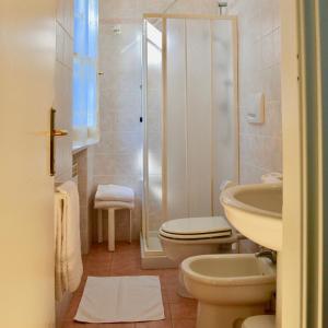 y baño con aseo, lavabo y ducha. en Hotel Villa Fiorisella en Marina di Massa