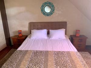 een slaapkamer met een bed met roze lakens en 2 nachtkastjes bij Eroilor Apartment in Cluj-Napoca