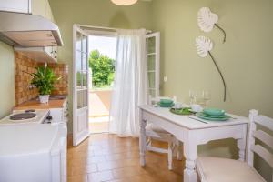 una cucina bianca con tavolo e sedie bianchi di Relax Studios Corfu a Roda