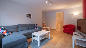 a living room with a blue couch and a red chair at Apartament 600 npm in Piechowice