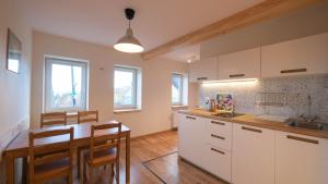 a kitchen with white cabinets and a table and chairs at Apartament 600 npm in Piechowice