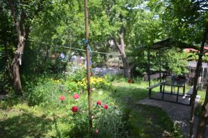 a garden with flowers and an umbrella and a bench at nikani in Borjomi