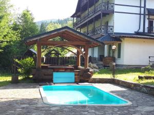 a swimming pool in front of a house at Котедж RIVER HILL in Mykulychyn