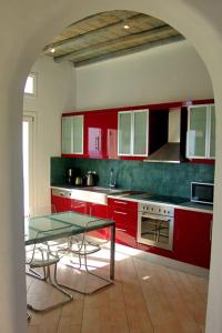 a kitchen with red cabinets and a glass table at Super 2 in Super Paradise Beach