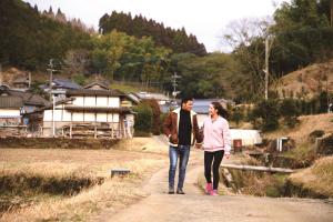 un hombre y una mujer caminando por un camino de tierra en Tubakiann, en Kikuchi