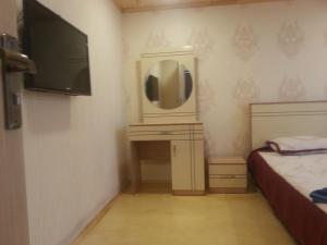 a small bedroom with a tv and a bed at Caspian Star in Sumqayıt