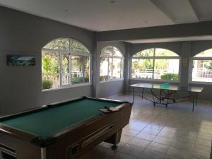 a pool table in a room with windows at Dionisos Blue in Paralia Dionysiou