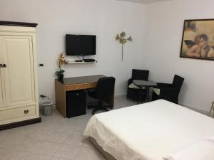 ラ・マッダレーナにあるB&B Mongiardinoのベッドルーム1室(ベッド1台、デスク、テレビ付)