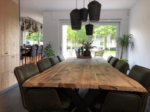 a dining room with a wooden table and chairs at Feel@Home De Westhoek in Koekelare