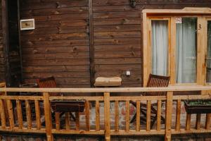 a porch of a cabin with two chairs and a window at Вилно селище Паздерите in Apriltsi