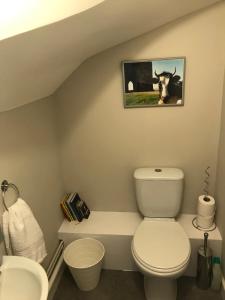 a bathroom with a toilet and a picture of a cow at 3 Crown Barton, Glastonbury in Glastonbury +6 photos