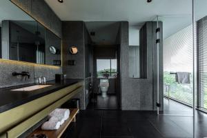 a bathroom with a sink and a toilet at MUH SHOOU XIXI HOTEL HANGZHOU in Yuhang