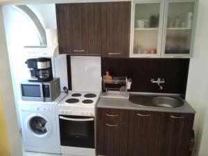 eine kleine Küche mit einem Herd und einer Mikrowelle in der Unterkunft Apartment Nedyalkov in Warna