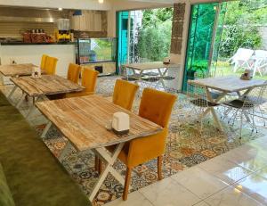 a restaurant with wooden tables and yellow chairs at Kadifeli Konak Hotel & Bungalow in Kocaeli