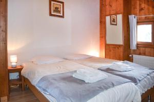 een slaapkamer met een bed met twee handdoeken erop bij MAISON ROSE 3 in Morzine