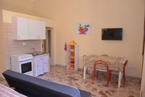 uma cozinha com uma mesa, um lavatório e um fogão em strada del corso da Alberto em Avola