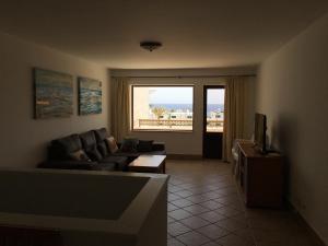 a living room with a couch and a large window at CDM, Puerto del Carmen, entre Playa Chica y Playa Grande in Puerto del Carmen