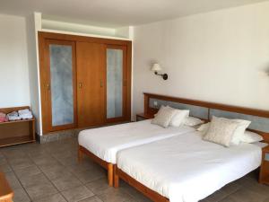 sypialnia z dwoma łóżkami i drewnianą szafką w obiekcie CDM, Puerto del Carmen, entre Playa Chica y Playa Grande w Puerto del Carmen