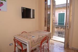 stół i krzesła ze stołem i balkonem w obiekcie strada del corso da Alberto w mieście Avola
