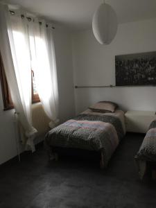 a bedroom with two beds and a window at Sous la tour in Agencourt