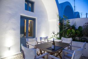 einen Tisch und Stühle auf einer Terrasse mit einer Flasche Wein in der Unterkunft Onirondas Villas in Fira