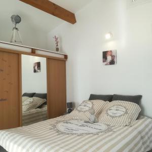 1 dormitorio con 1 cama con espejo en appartements dans villa avec terrasse, jardin, parking clos, wifi, en Meyreuil