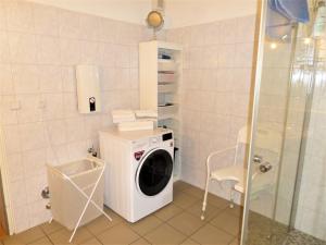 een wasmachine in een badkamer met een douche bij Beim Wels in Bad Zwischenahn