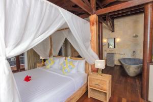Säng eller sängar i ett rum på Kudat Riviera Exclusive Beach Villas
