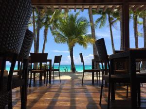 - un restaurant sur la plage avec des palmiers et l'océan dans l'établissement 357 Boracay Resort, à Boracay