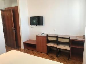 a room with a desk with two chairs and a tv at Villa Lucia premium rooms in Primošten
