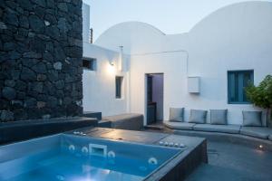 a living room with a hot tub in the middle of a house at Onirondas Villas in Fira