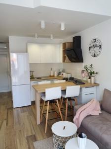 a kitchen and living room with a table and a couch at Apartment Magic in Stinica