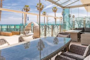 バレンシアにあるLuxury Beach Front Apartment with Poolの海を望むパティオ(テーブル、椅子付)