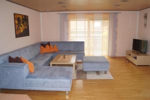 sala de estar con sofá azul y mesa en Ferienwohnung Hofbauer, en Hofkirchen