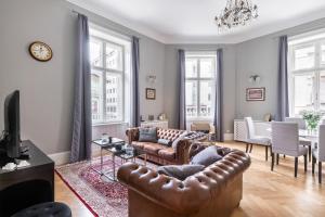 a living room with a leather couch and a table at Spacious Victorian Residence by Grand Boulevard in Budapest