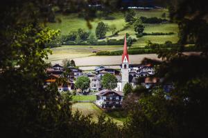 un petit village avec une église avec une cloche dans l'établissement Gourmet - Boutique Hotel Tanzer, à Falzes