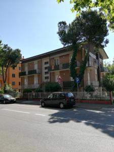 un edificio con coches aparcados al lado de una calle en Lally Appartamenti en Rímini
