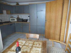 a kitchen with a table and a bottle of wine at Hotel Restaurant Biesenbach in Wipperfürth +11 photos
