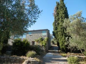 een pad dat leidt naar een stenen gebouw met bomen bij Gîte de campagne sud Ardèche les Vans in Les Vans