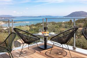a balcony with a table and chairs and a view of the water at Best Western Hôtel Alcyon in Porto-Vecchio
