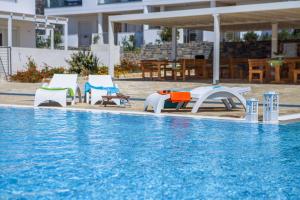- un groupe de chaises et une piscine dans l'établissement Villa Maria, à Makry Gialos